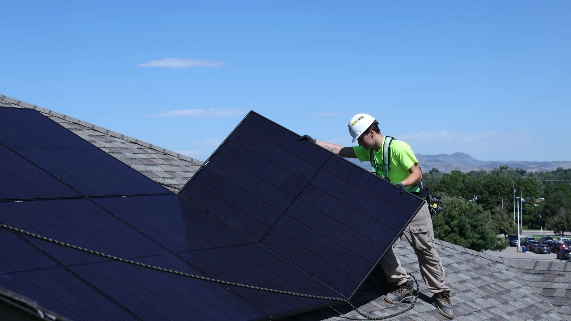 Installer Putting Solar Panels On A Commercial Roof